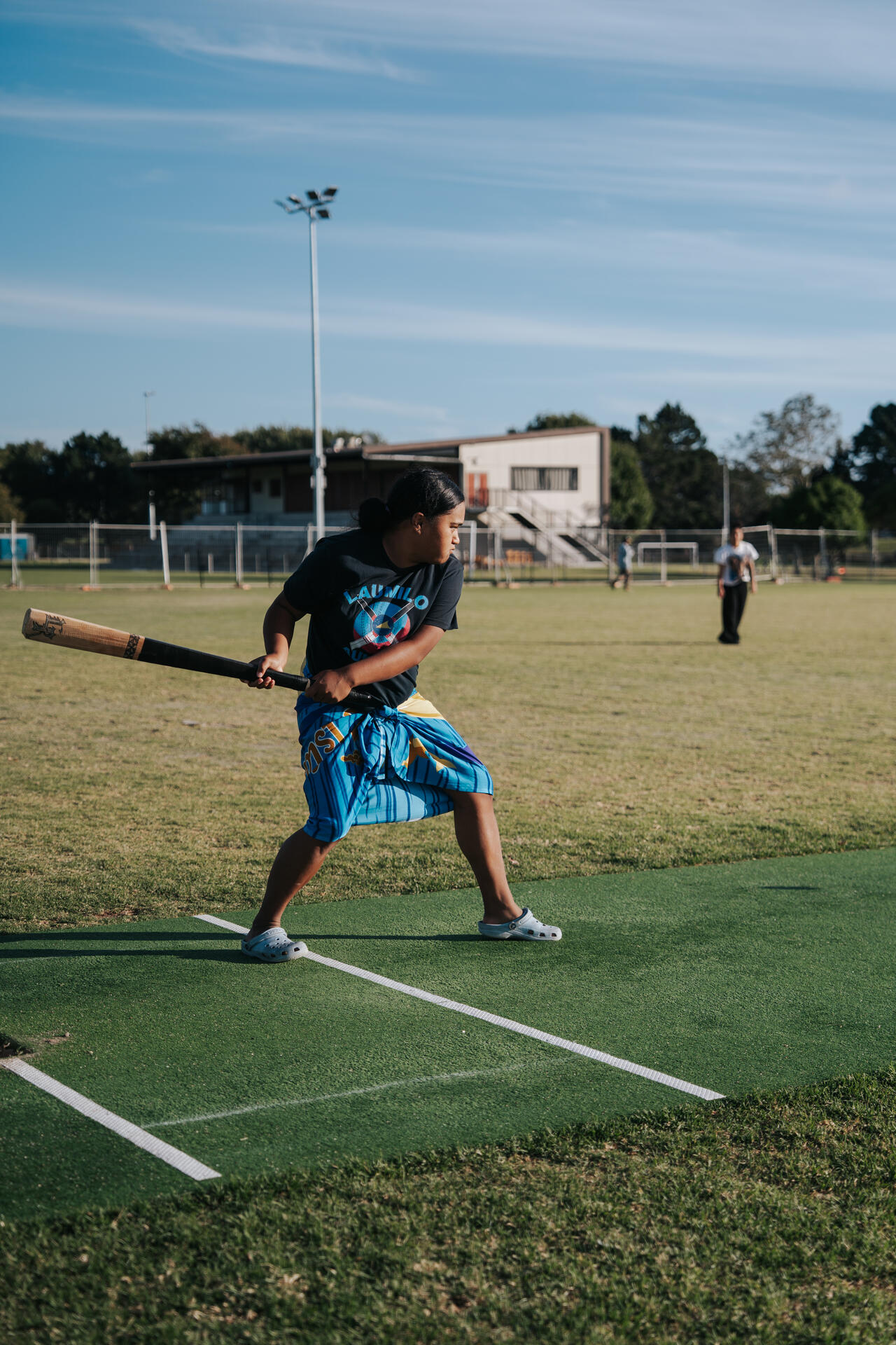 Young girl batting at kilikiti on the sports field
