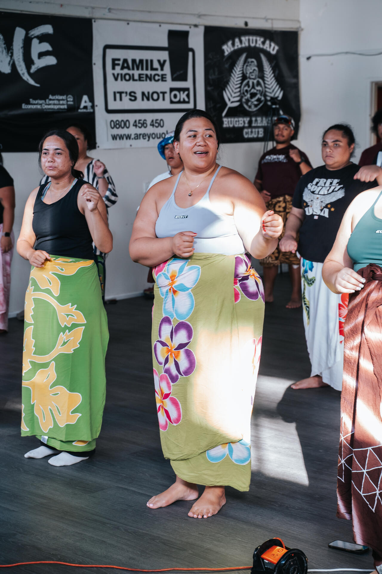 Women practising traditional dance in community hall