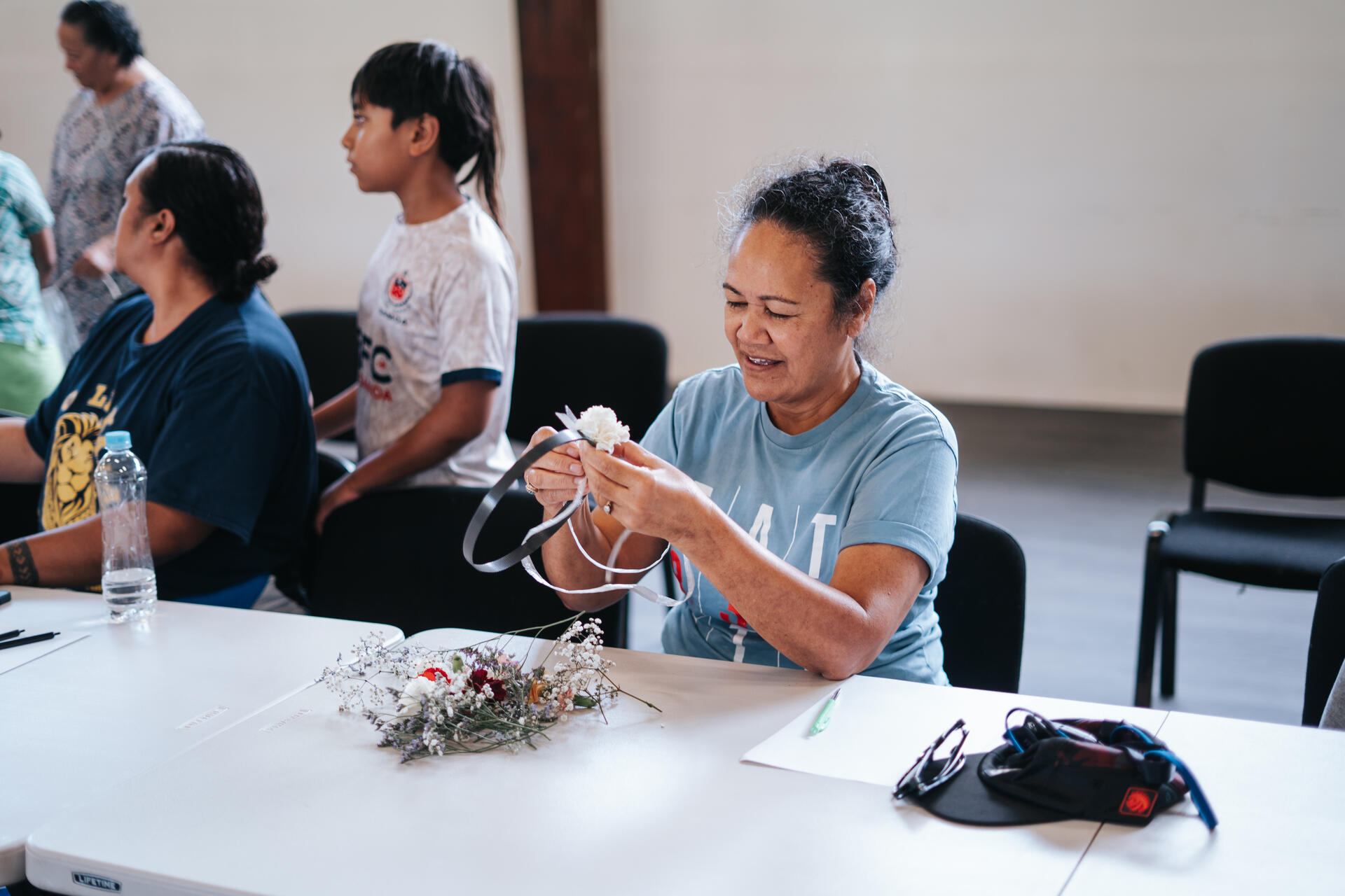 Elder crafting a flower arrangement at community workshop