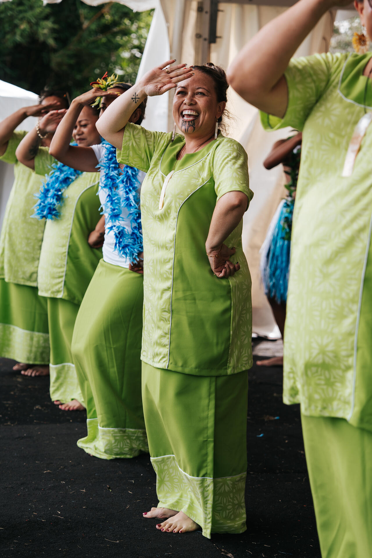 Women in green performing salute dance at Pasifika