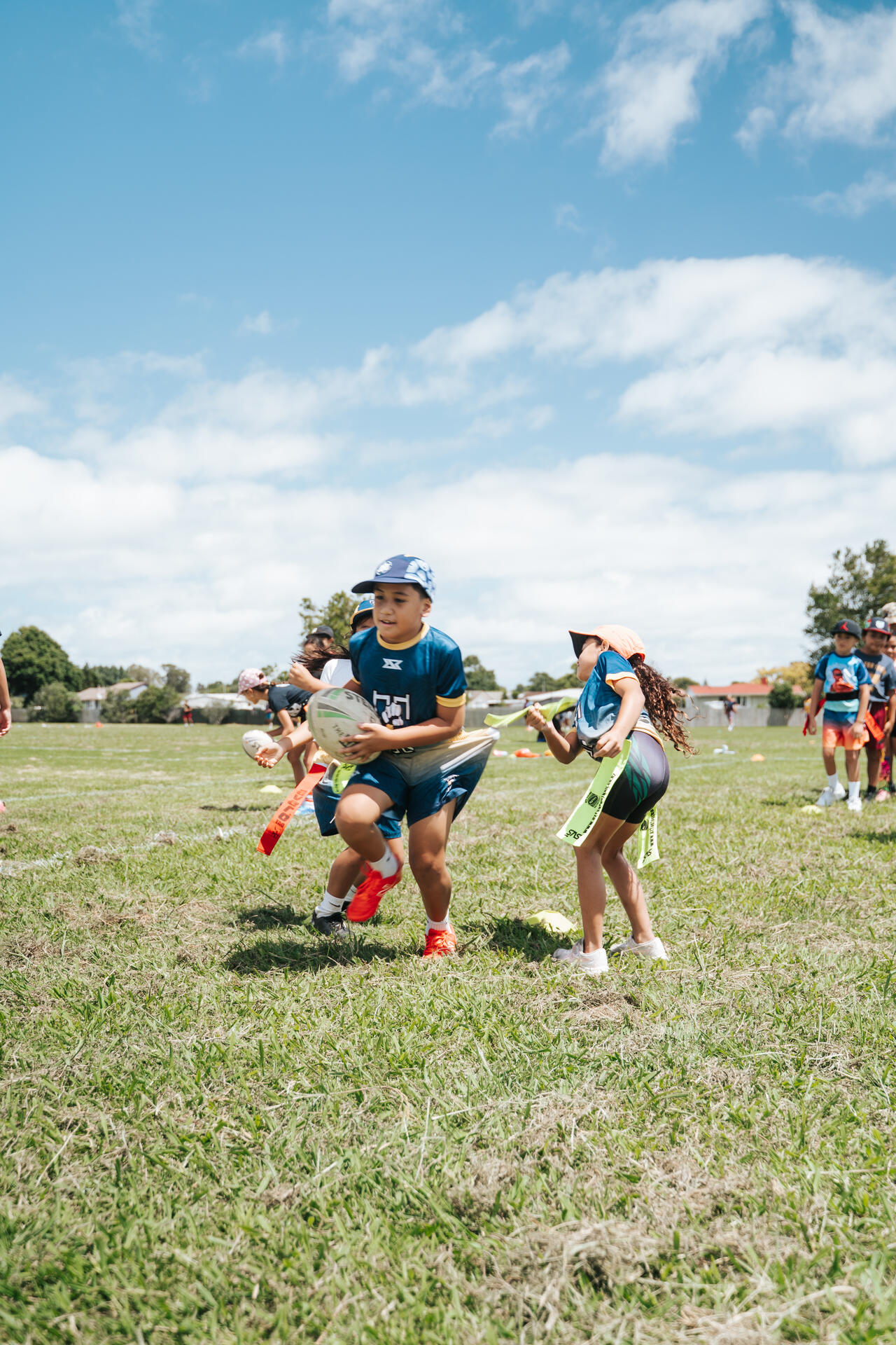 Kids playing rippa rugby on a sunny day