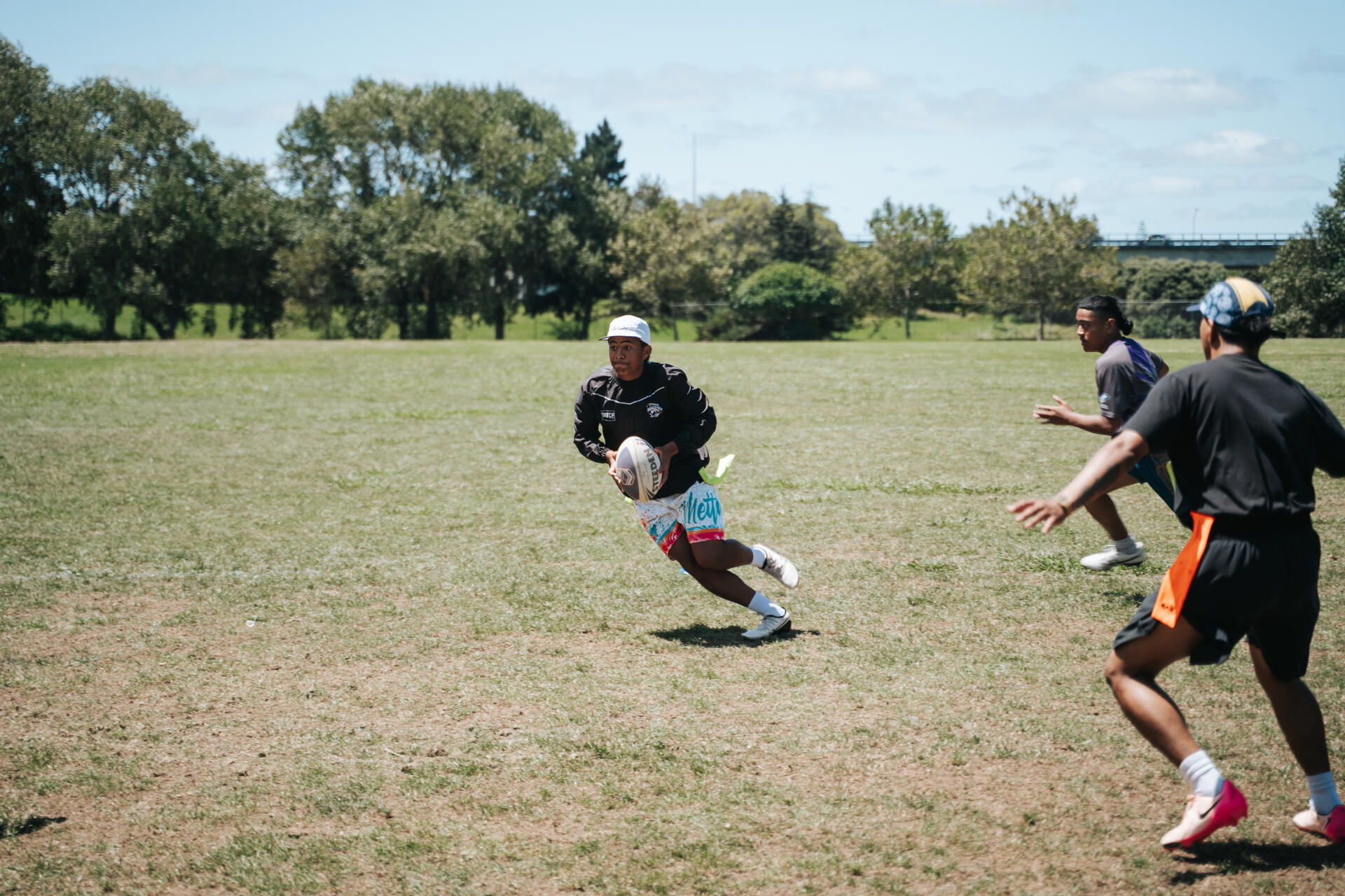 Youth rugby player running with ball on the field