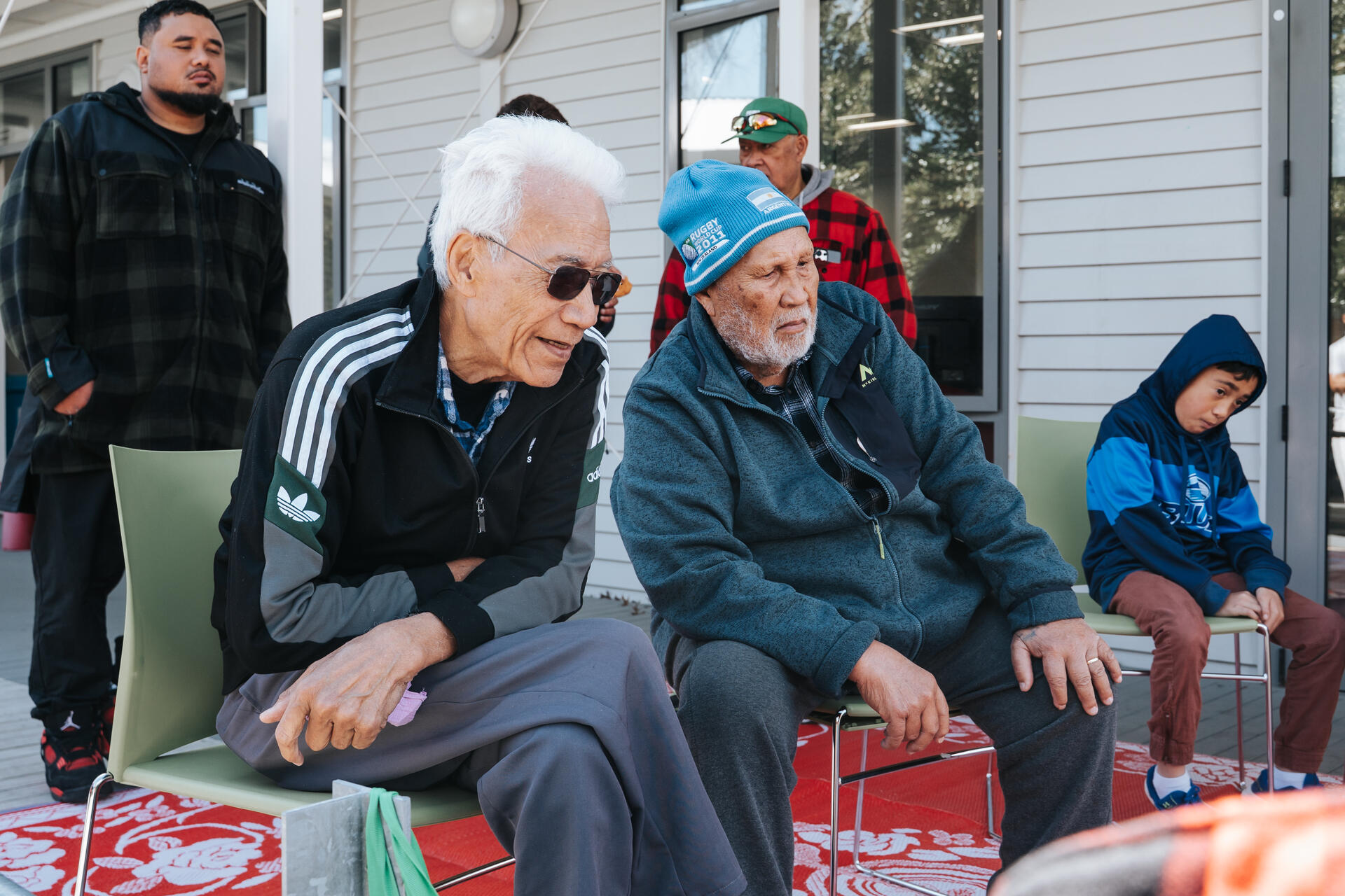 Two elders seated together at outdoor gathering