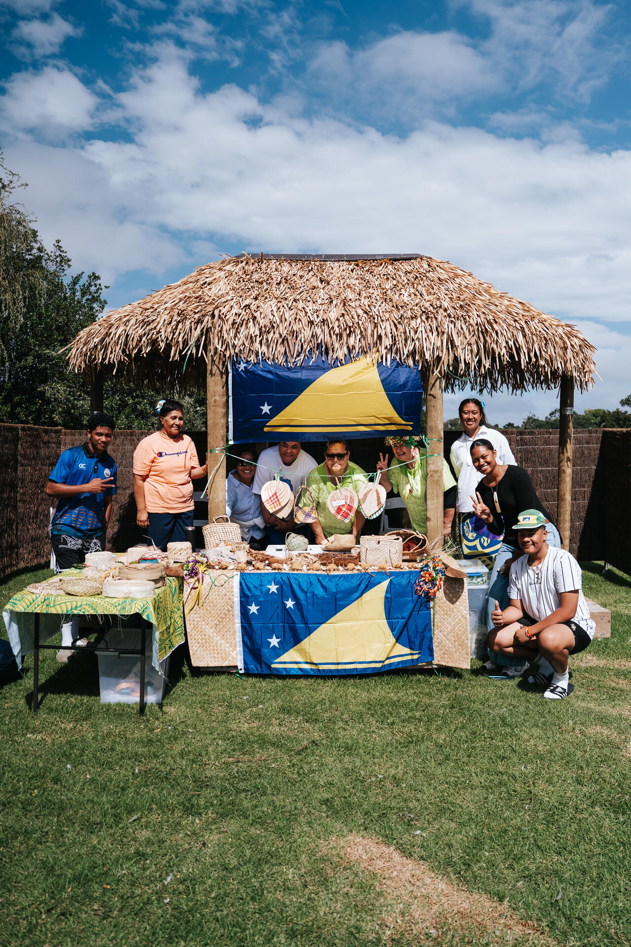 Community stall under traditional fale with Tokelau flag