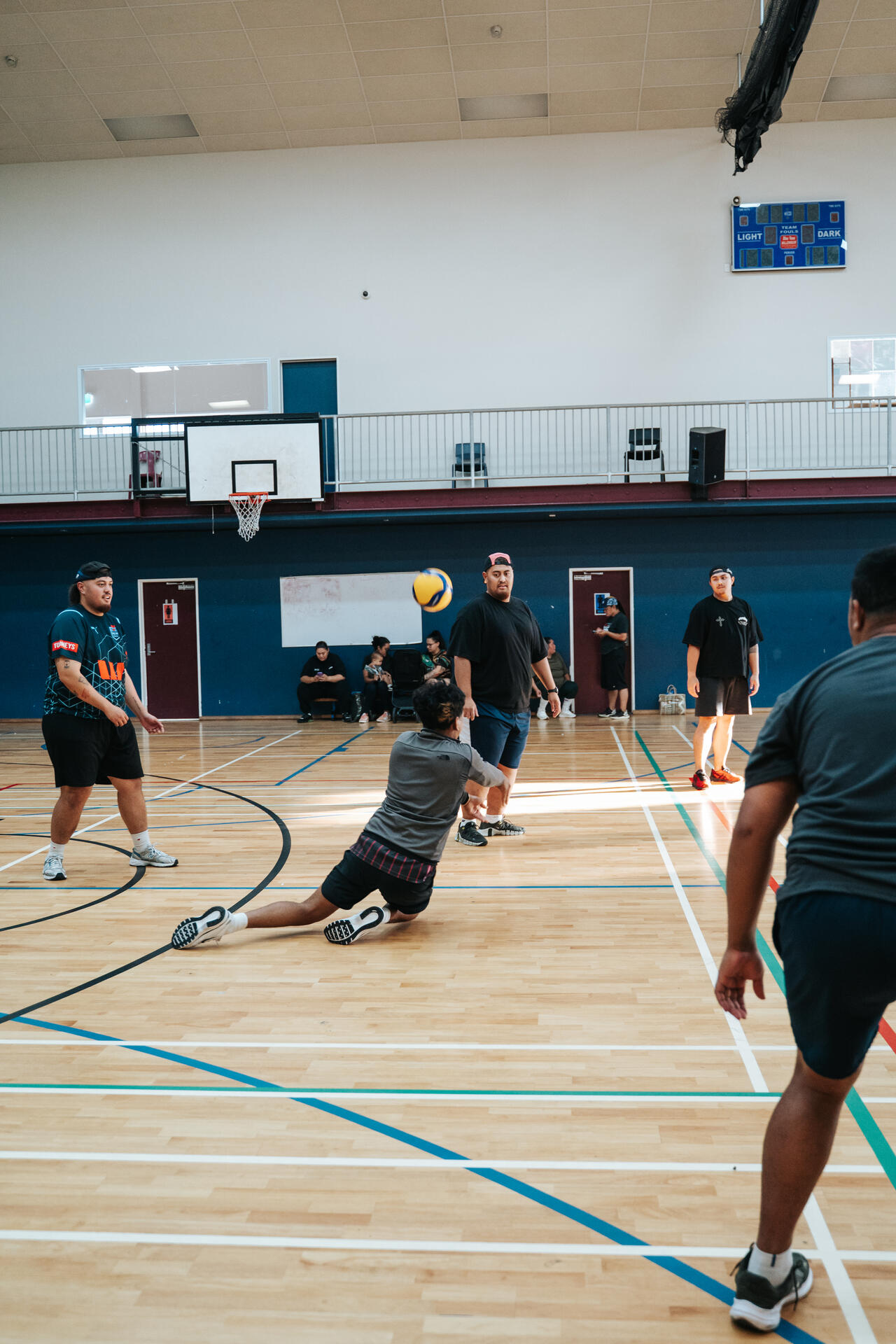 Volleyball player diving for the ball in indoor court