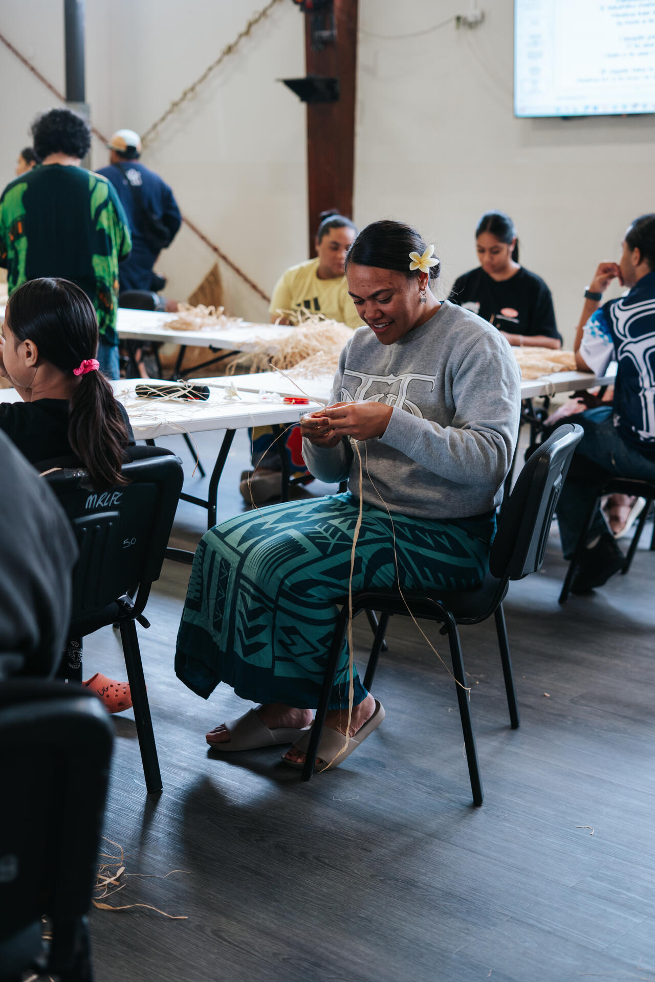 Woman with frangipani weaving at community workshop