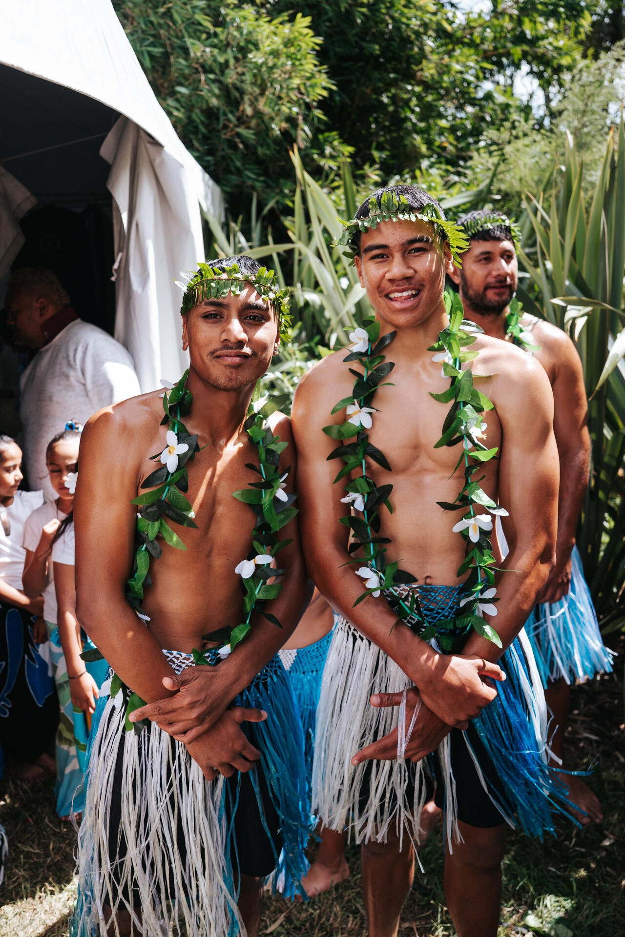 Young men in traditional Tokelauan dress with lei and grass skirts