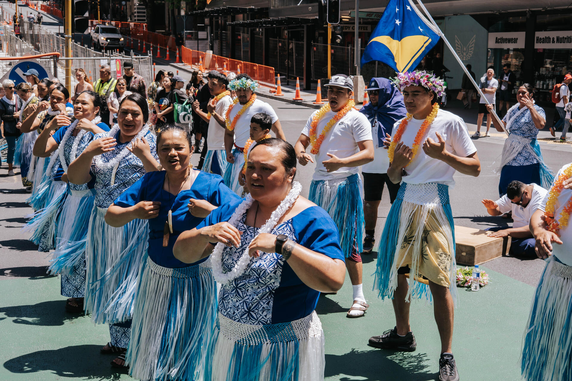 MTTA performing traditional dance in the city with Tokelau flag