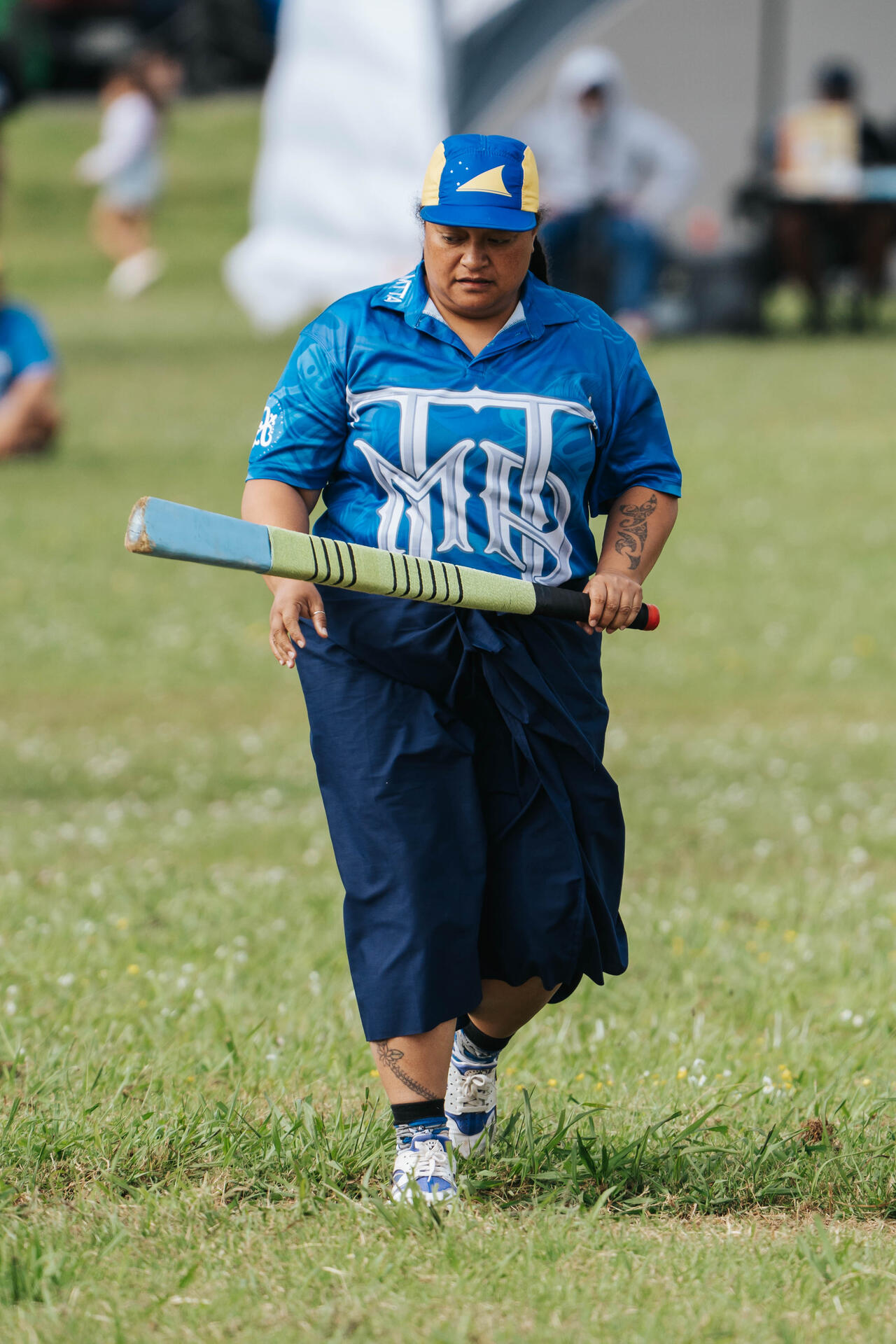 Woman playing kilikiti with bat on the field